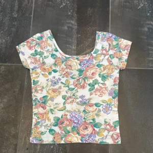  topp - Blommig crop topp från Bikbok i storlek xs. Jätte fin och snygg inför sommaren. Den är sann i storleken och är väldigt stretchig då den kanske kan passa även S. Inga defekter