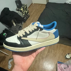 Jordan 1  Low fragment  - Jag säljer ett par snygga låga fragments. Dom är i bra skick lite smidigt på undersidan med inte på uppe fel på skon. Size 44 Travis scott skor 