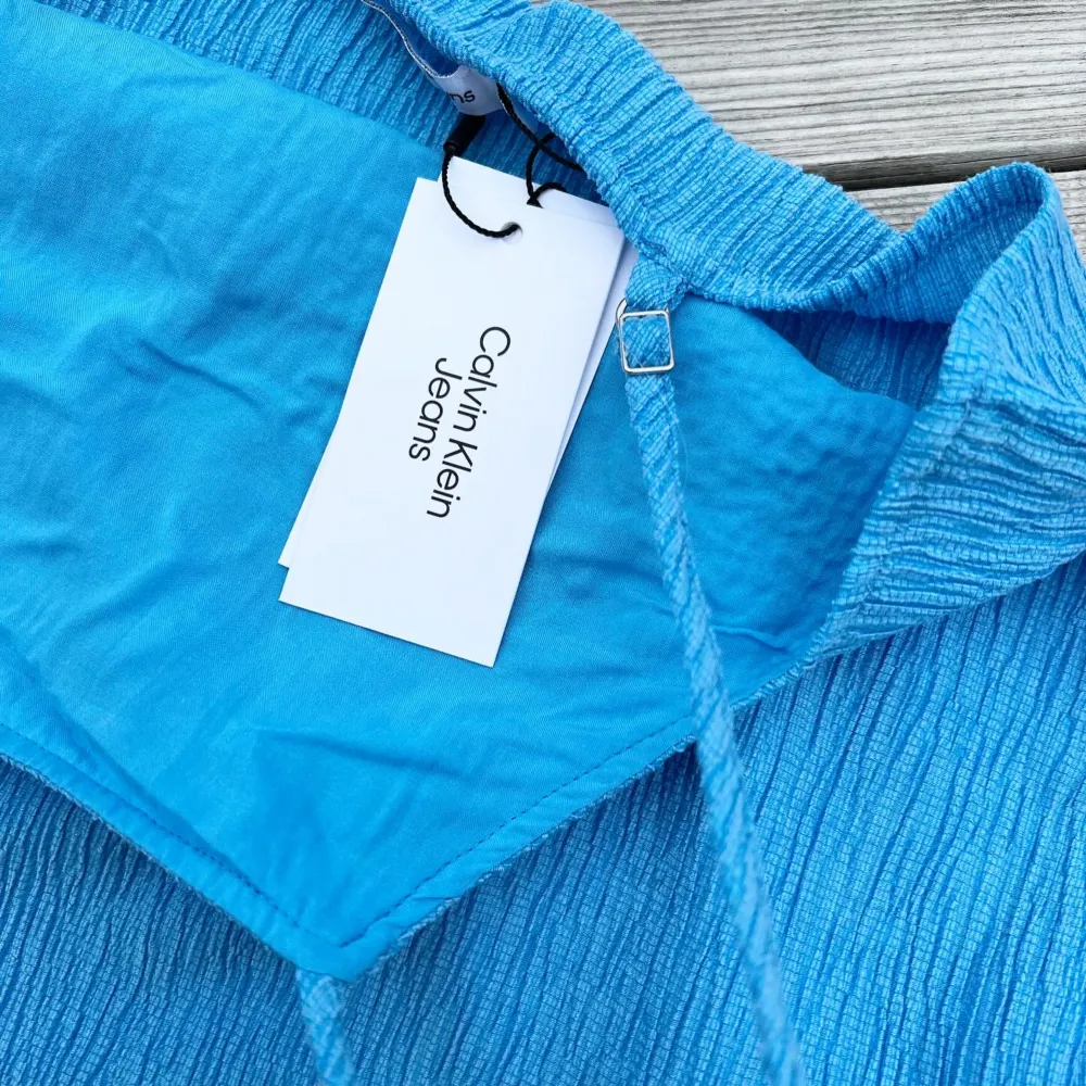 Calvin Klein linne, krinklat tyg, fodrad framsida/insida, storlek 14y, turkosblå, inköpt 2023 från @kidsbrandstore för 699kr, 65% lyocell, 34% polyester, oanvänd med lappar kvar, nyskick!. Toppar.