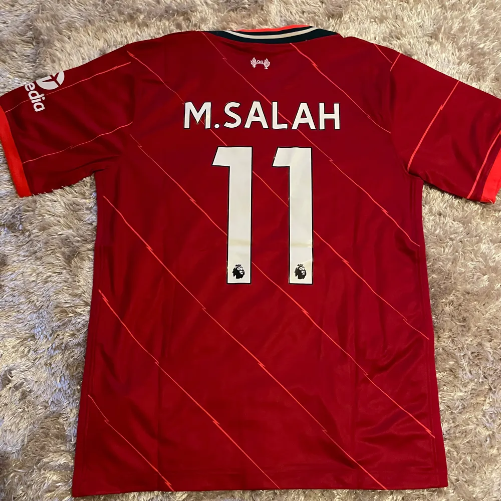 Säljer nu denna supersnygga Mohammed Salah tröja. Tröjan bär storlek L men passar även M. Helt oanvänd! Säljes för 249kr men kan gå ner i pris vid snabb affär!🤗. T-shirts.