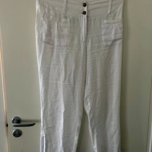 Vita Linnebyxor, Stl XL, Fr Masai  - Använda enstaka tillfälle, inget att anmärka på. Passar bäst på en 42/44. 100%Linne. De går lite nedanför ankeln på mig som är 1,67. Resår i midjan och blixtlås nedtill i benen.