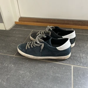 Philippe model - Ett par populära Philippe model i marinblå färg. Strl 41 men sitter större. Bra skick, ganska använda, lite slitna under annars ett bra helhetsintryck, har otroligt mycket kvar att ge. Inget OG, men självklart äkta. Fler bilder skickas gärna. Mvh VKO