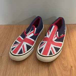 Sneakers strl 35 (36) - Oanvända sneakers i textil. Mörkblå med union jack flagga. Strl 35 men passar även 36