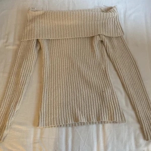 Stickad tröja - Stickad tröja som man viker så där över armarna jag har glömt vad det heter,den är ny skick ❤️ vit beige färg