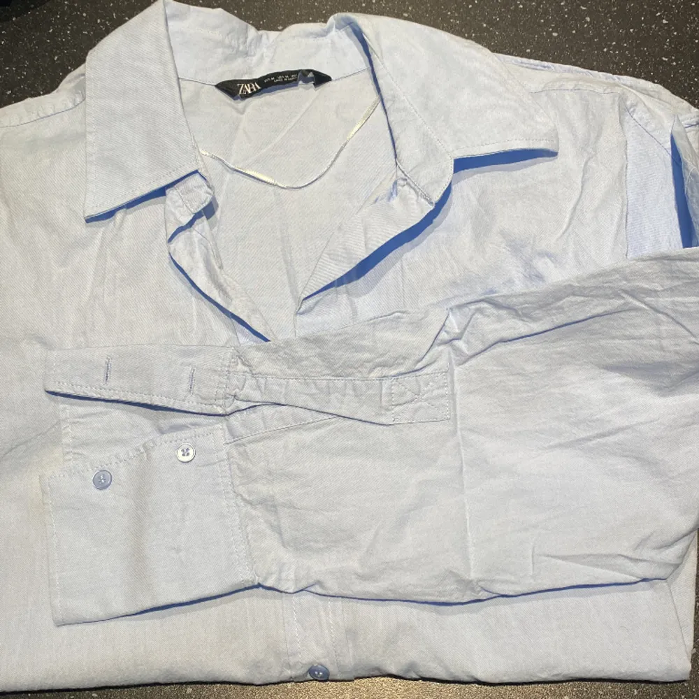 En ljusblå skjorta från zara. Aldrig använd. (Säljer då den inte kommer till användning).. Skjortor.