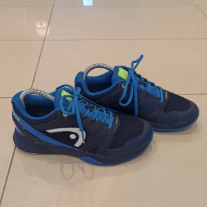 Marinblå inomhusskor - Marinblå inomhusskor från Head i storlek 39. Utmärkt skick, endast få små tecken på användning. Lite färg som försvunnit vid framsidan och en liten fläck vid innersidan. Perfekta för racketsporter såsom tennis eller badminton🌟 Skriv om du har frågor👍