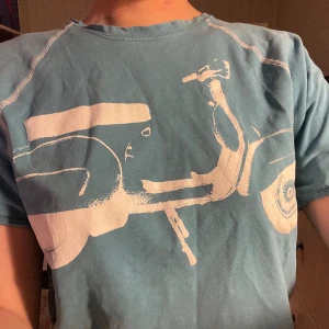 Vintage t-shirt med tryck - Tröja med coolt moped tryck från Lollopard som tyvärr aldrig kommit till användning. Det är barnstorlek L men hade sagt att det var mer som en M