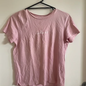 T-shirt - En rosa/lila tröja som det står ”lavender” på