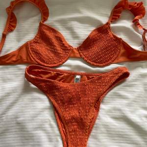 Bikini set i burnt orange färg, toppen har volangliknande stil på banden. Toppen 75 d och underdelen storlek m