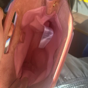 Maje väska - Superfin rosa maje väska! Väskan är använd och har på ena sidan lite missfärgning, jag har ej försökt att få bort fläckarna men det borde gå bort med mocka tvätt!!!🩷 fler bilder finns, kan skicka privat och dustbag medföljer!