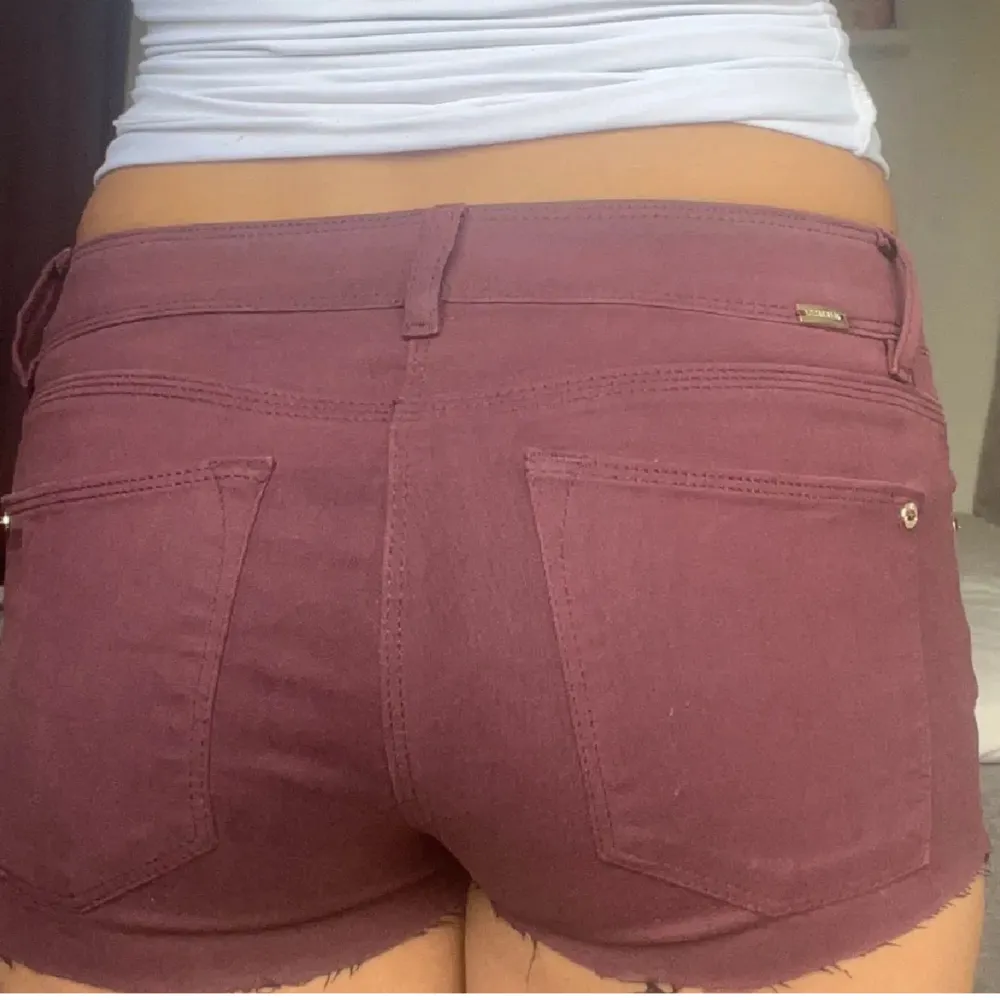 Lågmidjade jeansshorts i färgen vinröd midjemått rakt över: 37cm. Shorts.