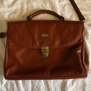 Väska  - Axelremsväska köpt secondhand, perfekt till skolan med många fack. Den är 35cm på längden och 26cm på höjden. Skriv för mer info/bilder, köparen står för frakt!💛