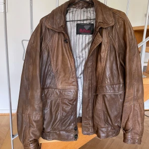 Brun läderjacka - Super snygg brun vintage läderjacka ! Äkta läder och köpt secondhand men i fint skick. Översta knappen är lite lös men det går lätt att fixa med lite nål och tråd 🥰 säljer då den tyvärr inte kommer till användning