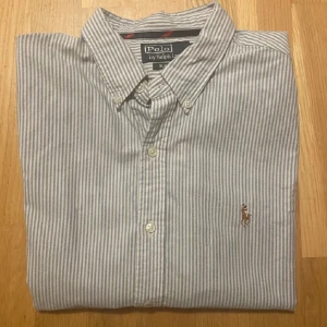Ralph Lauren Skjorta - Säljer denna vit/ljusblå stilrena ralph lauren skjorta. Riktig snygg och har inga tecken på användning eller slitage. Perfekt passform för dig som bär M