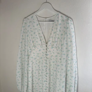 Adoore Positano vit med blå blommor klänning  - Säljer denna då den tyvärr inte passade mig, men tänkte att jag lägger ut denna om någon är intresserad av att köpa den innan ja skickar tillbaka den.   Storleken är 40, endast testad annars helt ny! 