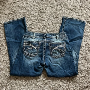 Lågmidjade vintage jeans  - Lågmidjade utsvängda vintage jeans med snygga detaljer i bra skick, köpt second hand men aldrig använda. Midjemått: 76 cm (38 rakt över)