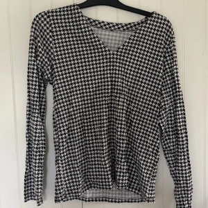 Hundtandsmönstrad Topp - Fett cool topp som knappt är använd.  Köpt på tradera för nått år sedan. Ingen aning om storlek eller märke, men den sitter lite tajt på mig som brukar ha stl L/XL.  Skriv om ni har frågor eller vill ha fler bilder!  Djur finns i hemmet! 