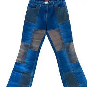 Flared blåa jeans med påsydda lappar av mocka och grått jeans tyg. Perfekt för en 70-tals look.