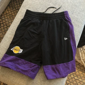 Lekers shorts  - Ett par oanvända Lakers shorts ifrån Newera som jag fick i födelsedagspresent som inte kommit till användning. Nypris ligger på 700 kr och skicket är 10/10. Hör av dig vid frågor :)