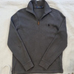 Ralph Lauren Half-Zip - Säljer en Ralph Lauren Halv zip. Snygg o stilren, bra skick. Mörkgrå färg, passar bra i storleken alltså en vanlig M.