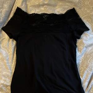 En jätte fin svart spets Tshirt som är of shoulder med spets högst upp