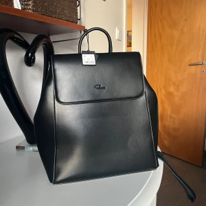 Ryggsäck - Svart ryggsäck som jag säljer åt min farmor då hon köpt fel. Helt oanvänd i nyskick, prislapp kvar. Köpt för 699 :- 🥰