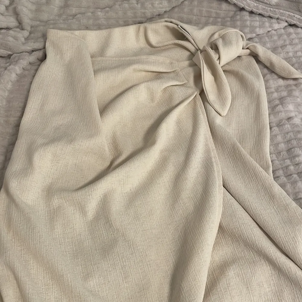 En kjol köpt från h&m som är en beigeaktig färg, använde den ganska så mycket i somras men inte längre eftersom den ej passar så bra nu. Skulle säga att materialet är väldigt hållbart och den känns som ny. Köpt runt ca 200-300kr.. Kjolar.