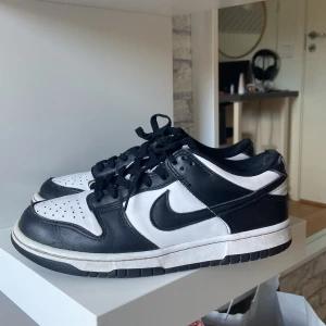 Nike panda dunks - Säljer mina ÄKTA Nike panda dunks som är i okej skick, de är lite smutsiga har försökt tvätta de lite och vid hälen är de lite uppdragna (se bild) annars funkar de fint, inga hål som läcker in vatten eller så. Skriv om ni har frågor eller fler bilder