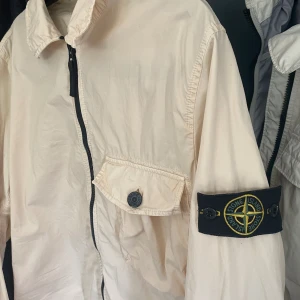 Stone island overshirt - En riktigt snygg vit/beige overshirt från det trendiga märket Stone island. Säljer denna pga att den bara hänger i garderoben, så skicket är utmärkt!