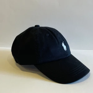 Svart Ralph Lauren Keps - Onesize, perfekt för sommaren, bra passform och populär bland tjejerna.☝️  Pris 250kr går att diskuteras vid snabb affär.