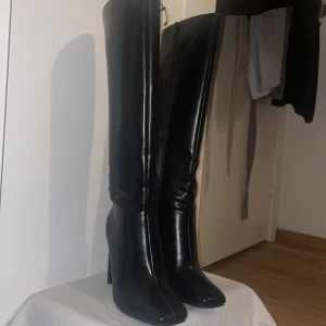 Knähöga boots - De här stövlarna har en knähög design. De har en dragkedja i sidan och fyrkantiga högklackade skor. De här stövlarna har en lyxig känsla.   - har använt bara en gång helt nya/ köpte de för 600kr och säljer den för 450kr:)