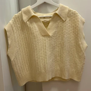 Croppad stickad väst - Något croppad beige stickad väst i storlek M