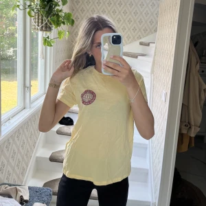 Gul t-shirt med tryck  - Jag säljer en gul t-shirt från Gina Tricot med tryck både på framsida och baksida. Säljer för att den tyvärr inte kommer till någon användning. T-shirten är i bra skick tyvärr lite skrynklig på bilderna🥰