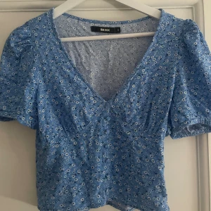 Somrig blus - Supersöt somrig blå topp som har blommigt mönster. I fint skick🙏💙