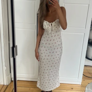 Blommig satinklänning - Vit satinklänning med rosa blommor från GinaTricot. Justerbara och smala band.  Köptes för 500kr. Använd vid 3 tillfällen, kommer ej till användning längre🤍🌸