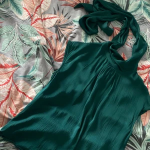 Blus/topp med knyte - Snygg grön blus/topp som man kan knyta på lite olika sätt runt/vid halsen🎀 använd endast en gång och i väldigt bra skick💗
