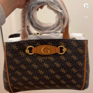 Guess väska - Helt ny väska, köpt för 1400kr.  Använd vid ett tillfälle, väldigt fint skick.