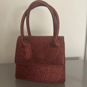 Röd glitter väska  - Röd glitter väska köpt på Nelly. Aldrig använd. 20cm bred 