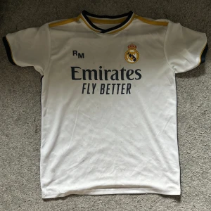 Real Madrid hemma kit 2023/2024 - Mycket bra skick på tröjan då det inte är någon fläck eller så vidare på den. Tröjan har Vini JR Nr 7 på baksidan. Säljer den pågrund av att den sitter tajt på mig. Obs dem är stor i storleken 