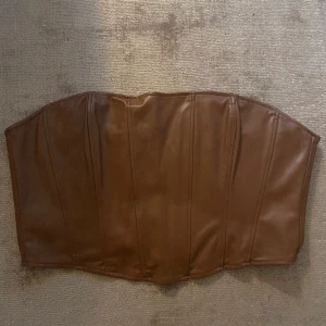 Brun korsett topp - Brun korsett topp från Zara. Använt 2-3 gånger. Är i ett fint skick.