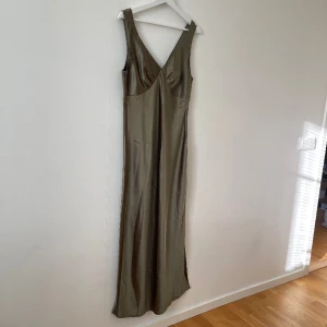 Balklänning khaki - Super fin balklänning från Asos köpt på Vinted (det är inte jag som klippt av lappen). Drömigt silkesliknande tyg! Med slit vid benet. Som ny🥰 skriv vid frågor. Är L men passar även medium