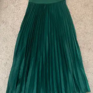 Plisserad mörkgrön kjol från hm i storlek s med resår i midjan. 