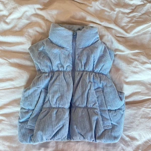 Y2K Väst cropped babyblå XS - Fin croppad väst i babyblå, i manchester liknande material från H&M. Strl XS.   Bra skick, knappt synliga sminkflöckar på innersida av kragen.  Köparen står för frakten. Fråga mig gärna om fler bilder eller annat! 
