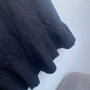 Svart klänning  - Svart klänning i tjockare material, perfekt för svalare sommarkvällar/höst. Otroligt stretchig med resår i midjan och trekvartsärm. Storlek M men hade kunnat passa en S också. En mindre volang nertill 