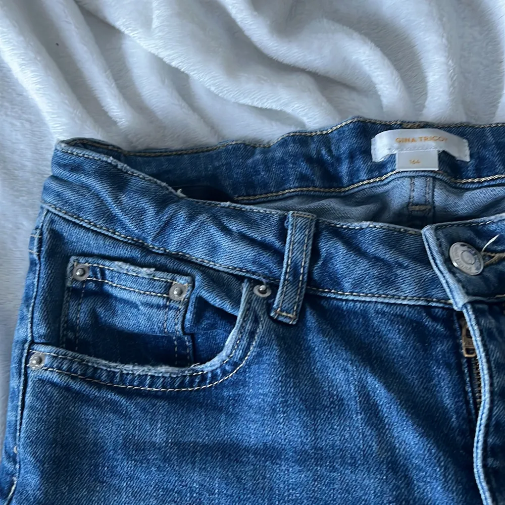 Low waist bootcut jeans från Gina tricot young size. Byxorna är använda men inte slitna. Hålen är klippta för att få jeansen unika. Det går även att spänna åt jeansen i midjan. Jeans & Byxor.