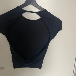 T-shirt med öppen rygg  - Ganska tajt, använd fåtal gånger. Öppen rygg, köpt på bershka.