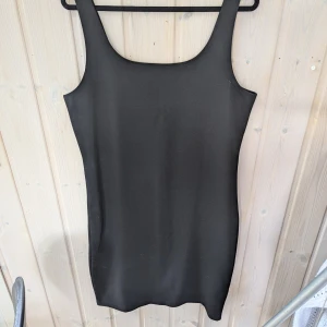 Svart klänning från BikBok - En svart ärmlös klänning från BikBok i storlek XL. Klänningen är tillverkad av 73% återvunnen polyester, 24% viskos och 3% elastan. Den har en enkel och elegant design med en rund halsringning.mycket fint skick, använt endast en gång,liten i storlek 