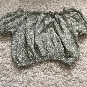 Grön blommig blus. - En jätte söt blus ifrån xoxo friends. Den har små puff ärmar, köpte den för ungefär ett år sedan. Men den är för liten.