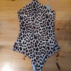 Leopard mönstrad body från H&M - En leopardmönstrad body från H&M tillverkad av 87% återvunnen polyester. I storlek XS. Den är HELT ny med prislapp kvar. Nypris 99 kr, säljer för 60 kr.