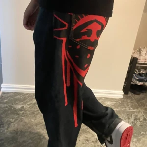 Baggy jeans med tryck - Bekväma jeans i storlek W30 (Medium) med rött tryck bak på båda sidor som inte går bort i tvätten. Endast testad fåtal gånger då dem inte riktigt passar mig och min stil.  Köpt för 700:-